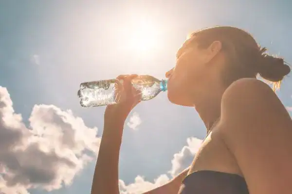 Hydration: The Secret Ingredient for a Toned Stomach and Enhanced Fitness 3 Image of woman drinking water to hydrate Kenilworth after run.